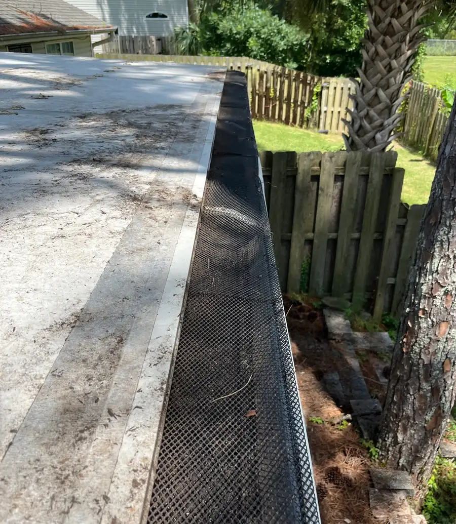 Gutter cleared of pine needles and debris, with its leaf mesh back in place