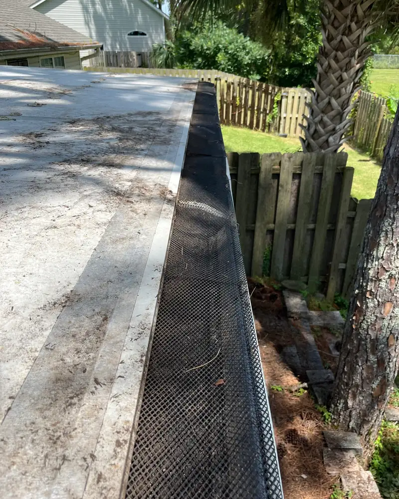 The same gutter cleared of debris, with its leaf mesh back in place