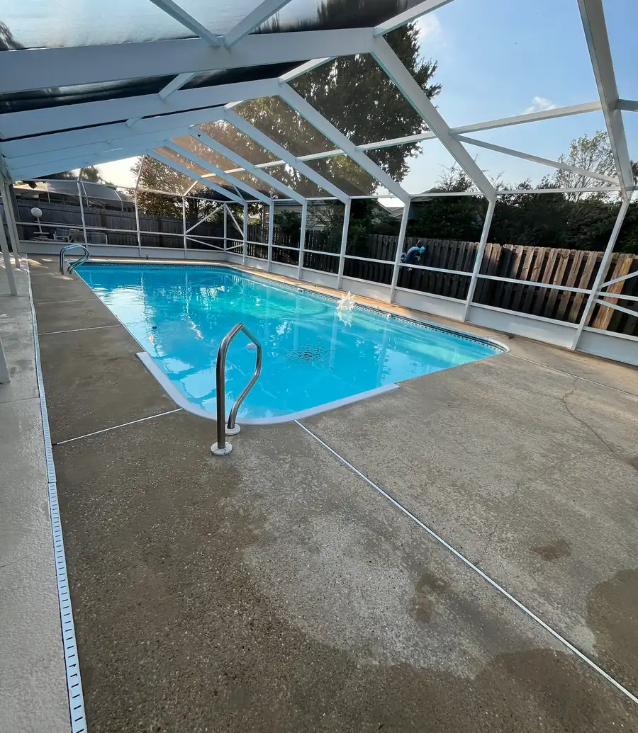 Clean concrete pool deck inside a screened pool enclosure after pressure washing