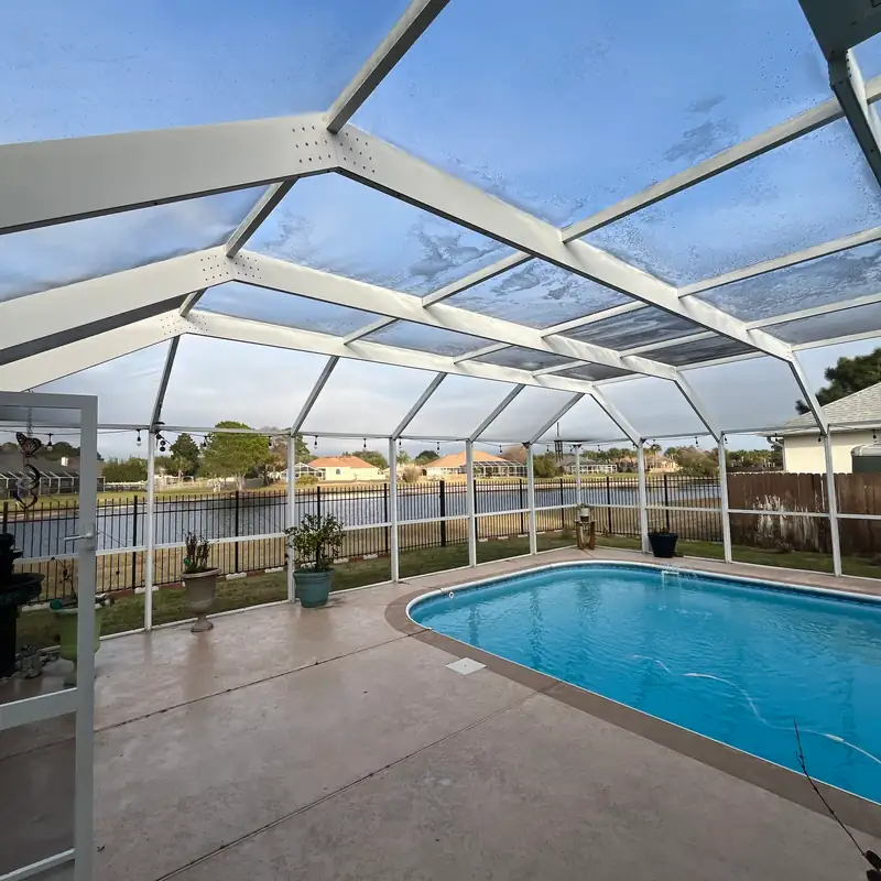 Pool enclosure roof screens and white frame, seen from inside the cage