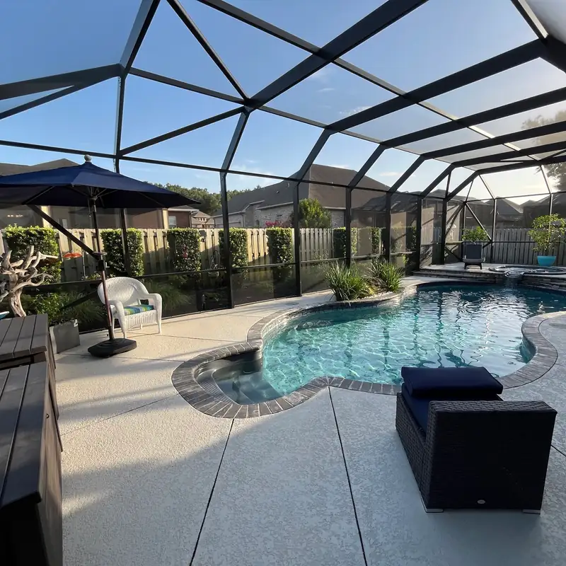Inside a rescreened pool cage: new black screen over a curved pool and lanai
