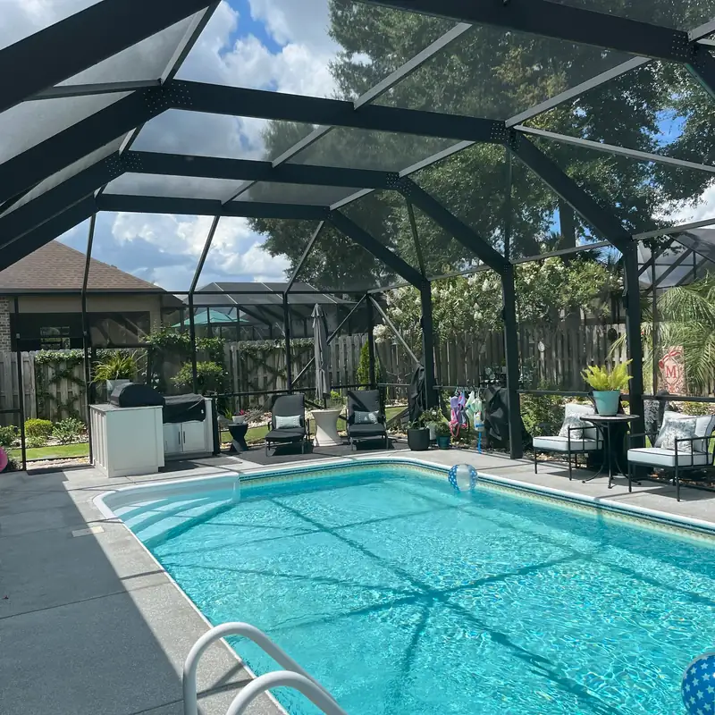 Pool and lanai under a newly rescreened black pool cage