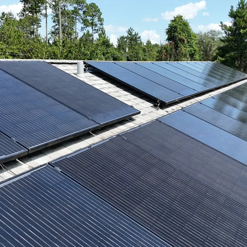 Close-up of rows of black solar panels on a shingle roof